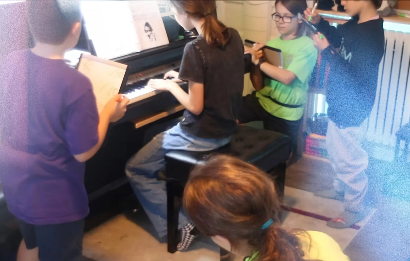 Un groupe d'élèves rassemblés autour du piano pendant une classe.